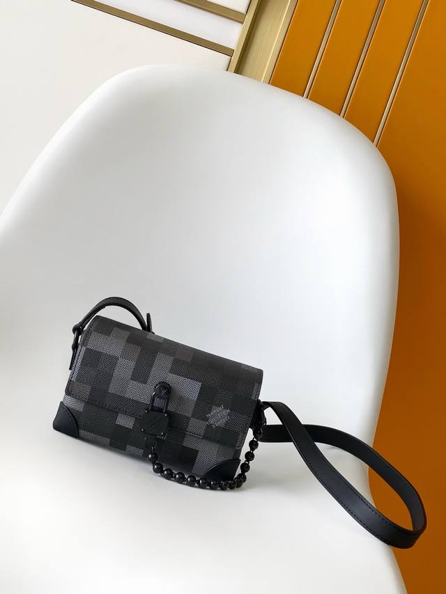 M14923 本款Steamer迷你手袋以Damoflage Black涂层帆布呈现Pharrell Williams的俊逸考究设计。像素化Damier Gra
