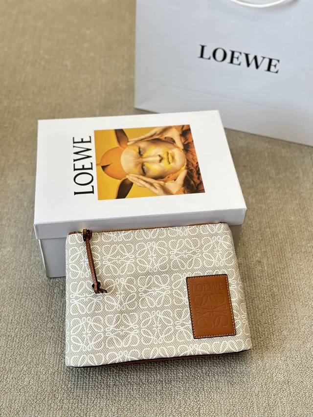 Loewe's new canvas clutch. This Ogo canvas clutch features a widened base for am