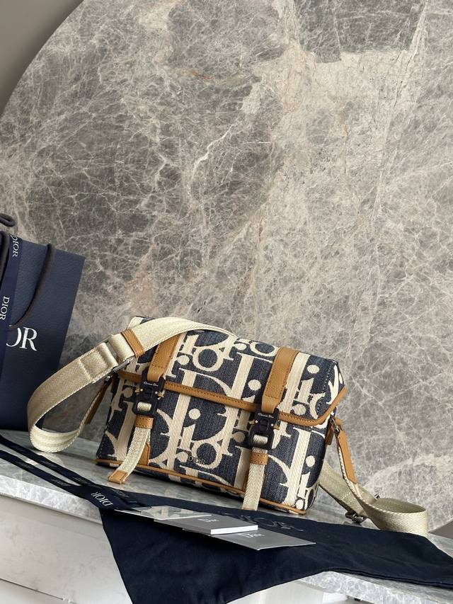 这款翻盖信使包以现代时尚的设计突显 Dior 的高订精神，进一步丰富 Dior Hit The Road 系列。采用蓝色酒椰草效果 Oblique 印花牛仔面料