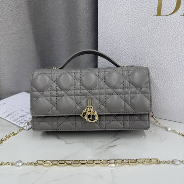 0980羊皮灰白色 Lady Dior 珍珠手拿包 这款手拿包是本季新品，顶部搭配手柄，优雅实用，令 Lady Dior 系列更加丰富。采用羊皮皮革精心制作，饰