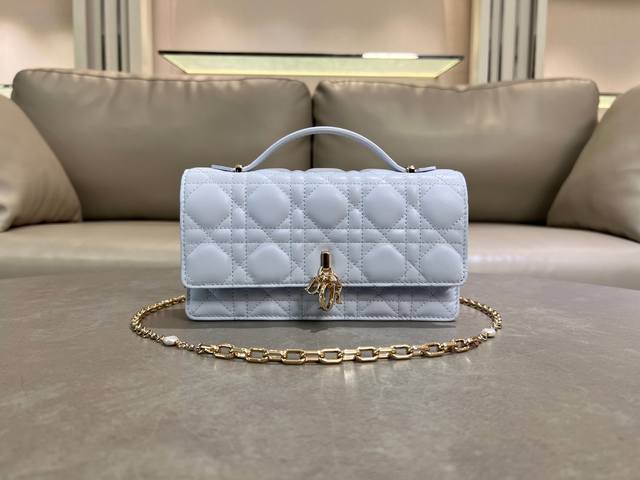 0980羊皮淡蓝色 Lady Dior 珍珠手拿包 这款手拿包是本季新品，顶部搭配手柄，优雅实用，令 Lady Dior 系列更加丰富。采用羊皮皮革精心制作，饰