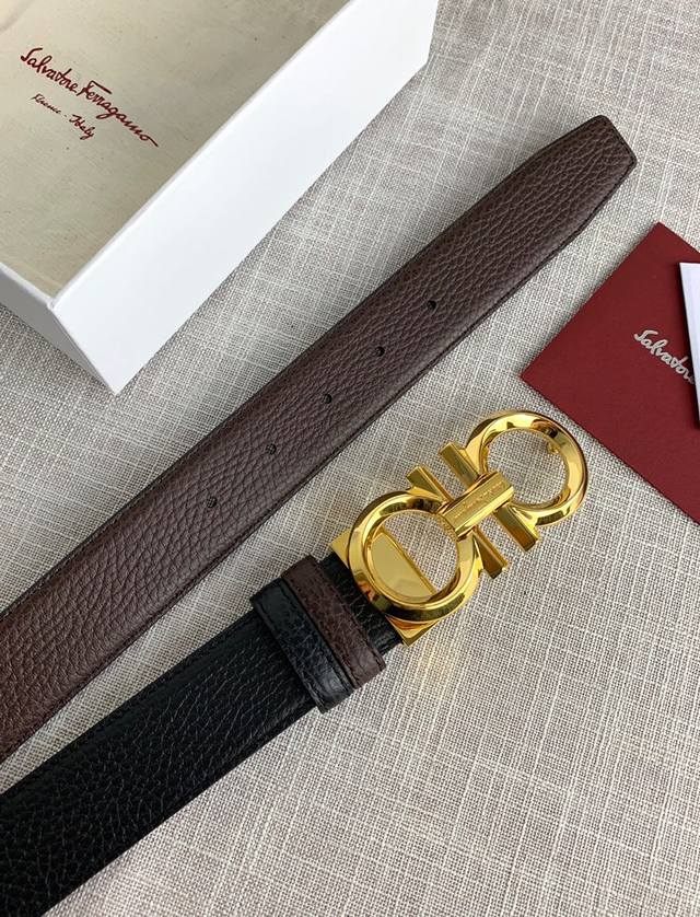 配全套包装盒 菲拉格慕L双面可调式皮带，配有亮光钯色Gancini双扣，为优雅造型增添一丝精致格调。黑色配咖啡，双面可用。该皮带可调节，且能根据需要剪裁，达到修