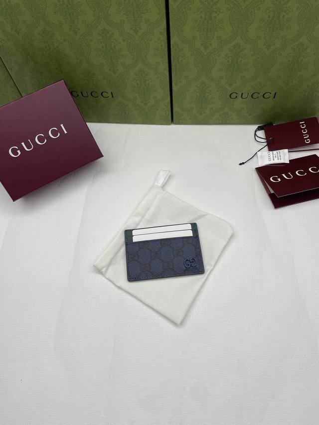 This bi-fold wallet is crafted from supple Gg Supreme material, featuring a stri