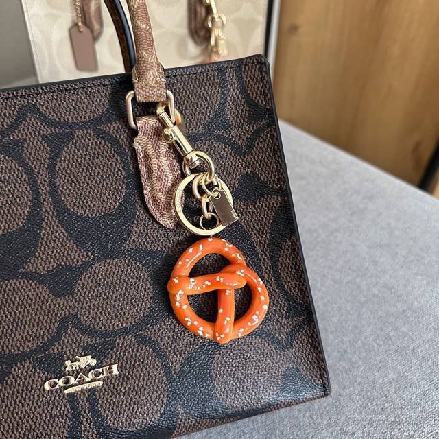 Comes with a pendant and gift box. Coach's new Maggie bag. Stylish and elegant.