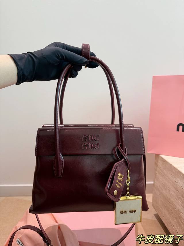 牛皮 配挂件 Miu Miu Solitaire手提包 Miu Miu Solitaire手提包，黑色亮面皮革，质感细腻又耐用，简约大气设计，正面品牌标志超有辨