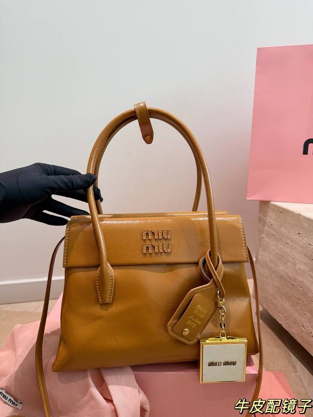 牛皮 配挂件 Miu Miu Solitaire手提包 Miu Miu Solitaire手提包，黑色亮面皮革，质感细腻又耐用，简约大气设计，正面品牌标志超有辨