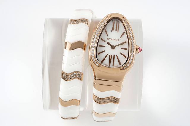 宝格丽Serpenti Spiga系列腕表35毫米的18K玫瑰金或精美抛光的不锈钢表壳内。表冠的顶端嵌入一枚鲜艳欲滴的红碧玺。表款将同时推出间白色陶瓷、间黑色陶