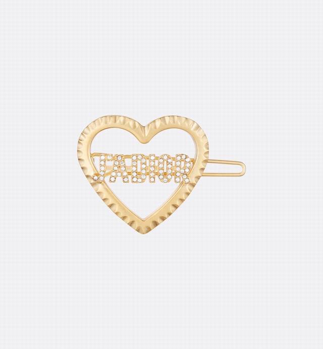 这款新款迪奥 Jadior发夹采用原创的优雅设计。爱心造型采用金色饰面金属打造。中间饰以镶嵌白色仿水晶的Jadior标志，可与Jadior系列其他单品搭配，打造