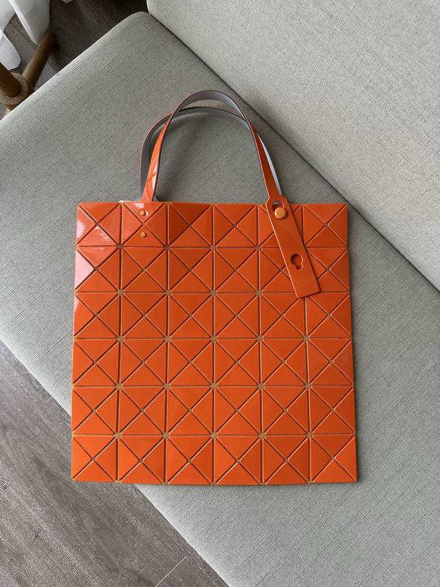 三宅一生 五月新品 六格亮面同色系列--橙色lucent系列托特包采用具有光泽的漆面材料制成。通过使用与三角珠片相同颜色的纱线织就而成的网眼面料与衬里，打造出一