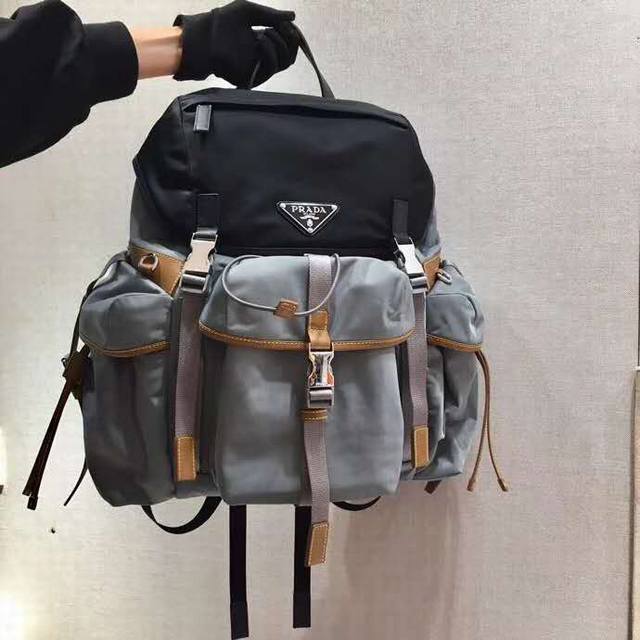 新款双肩背包2Vz074背包采用saffiano皮革饰边的织物面料制作，呈现兼具功能性和现代感的设计特色。背包配有多个口袋，撞色色调和对比鲜明的材质跃然包身，醒