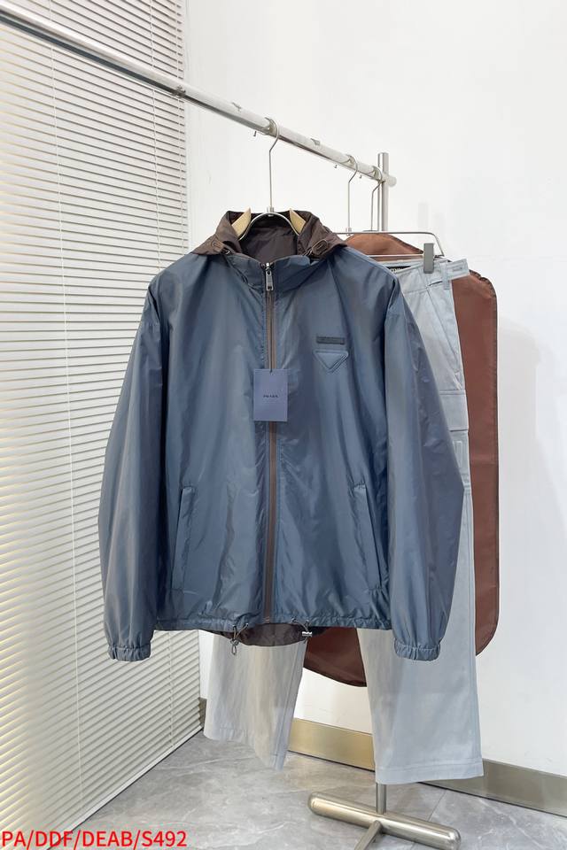 S492 pa prada 再生尼龙双面穿夹克选用品牌标志性的再生尼龙面料，与传统尼龙性能相当，具备高强度，抗撕裂，耐磨损等特性。其质地轻盈，同时又具备防水功能