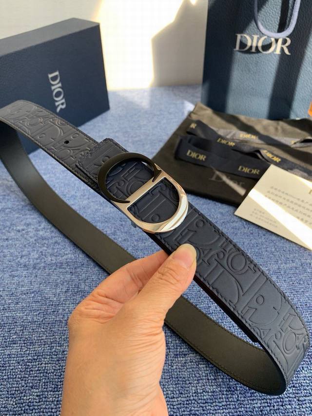 这款 35 毫米双面腰带结合典雅气质与摩登风范。 55095。 配一面采用黑色 Dior Gravity 印花效果皮革，以牛皮革融合压花工艺，演绎经典的 Obl