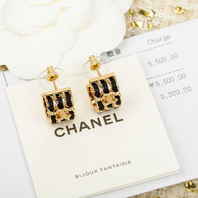 Black half-circle leather stud earrings with intricately carved lettering, 26p.