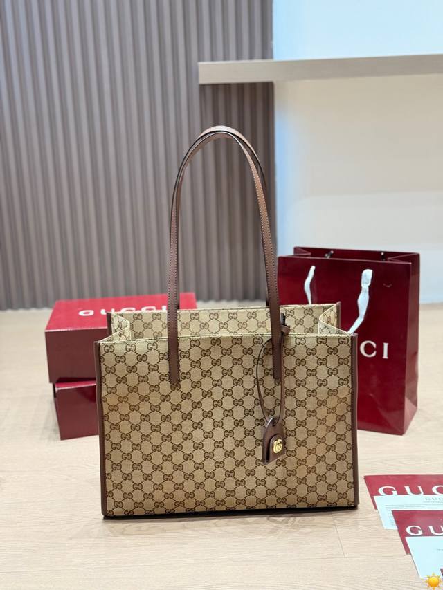 原版布 Gucci Gg Emblem托特包 Gucci Gg Emblem托特包，经典双G老花帆布+棕色皮革饰边，复古又时髦！大容量设计，通勤、旅行都能装下电