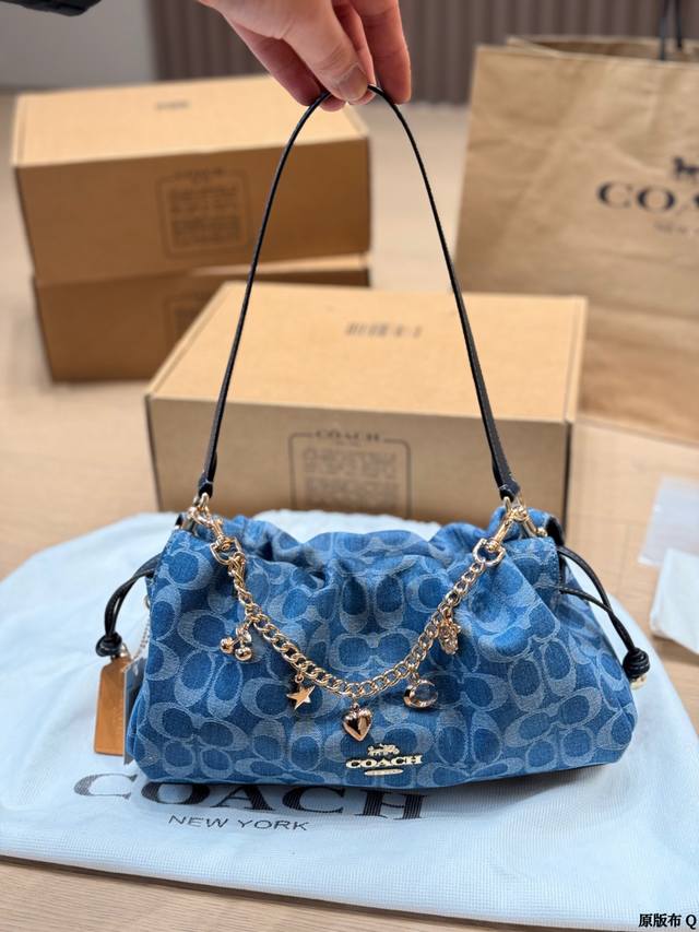 复刻版 Coach丹宁云朵包 Coach丹宁云朵包，经典C纹提花牛仔布，复古蓝色调超有氛围感！抽绳包口+金属链条，星星、爱心、月亮挂件点缀，细节满分。深棕皮质肩