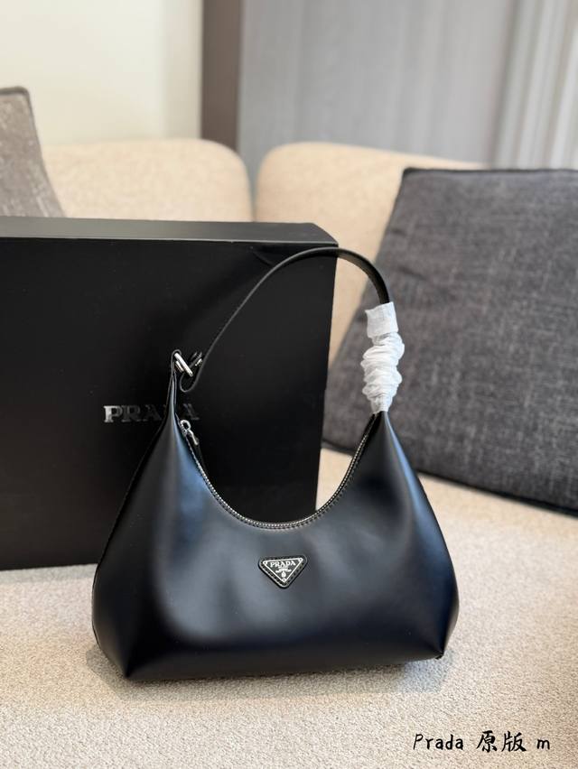 prada Cleo黑色腋下包 prada Cleo黑色腋下包，亮面皮革+经典三角Logo，简约又超有辨识度！Hobo包型，线条流畅，手柄缠白色布条，细节满分。