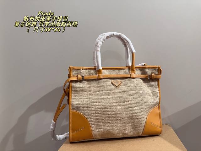 无盒38*30 prada帆布拼皮革手提包 prada这款手提包采用米色帆布+黄色皮革拼接，简约又有辨识度。正面三角Logo超有质感，手提+可调节肩带，手提斜挎