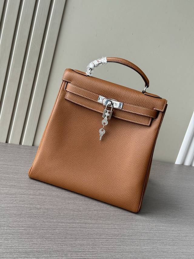 这是一款最新爆款爱马仕手提Kelly Ado Gm28Cm大号双肩包 也叫Kelly Backpack ，属于经典Kelly包的衍生款式 外观特征：金棕色Tog