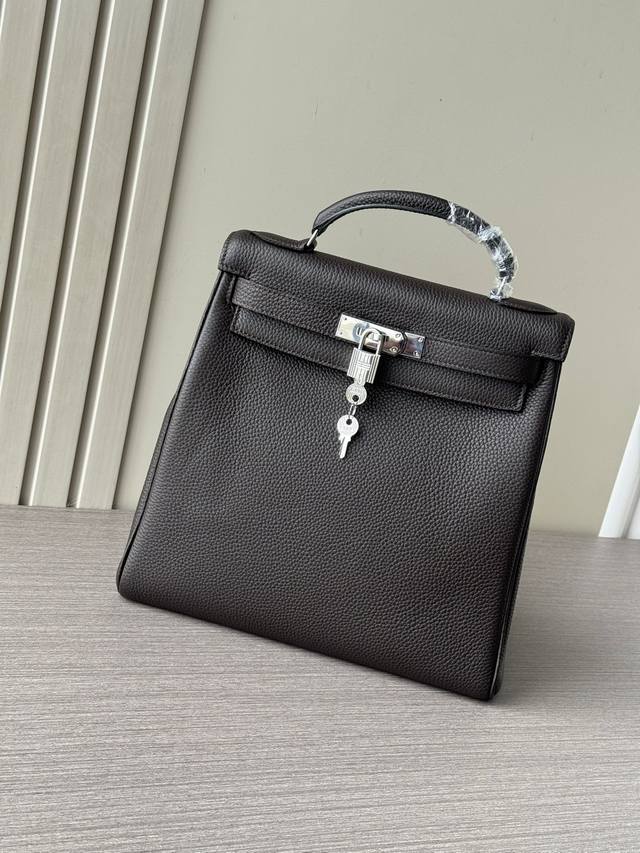 这是一款最新爆款爱马仕手提Kelly Ado Gm28Cm大号双肩包 也叫Kelly Backpack ，属于经典Kelly包的衍生款式 外观特征：乌木色Tog
