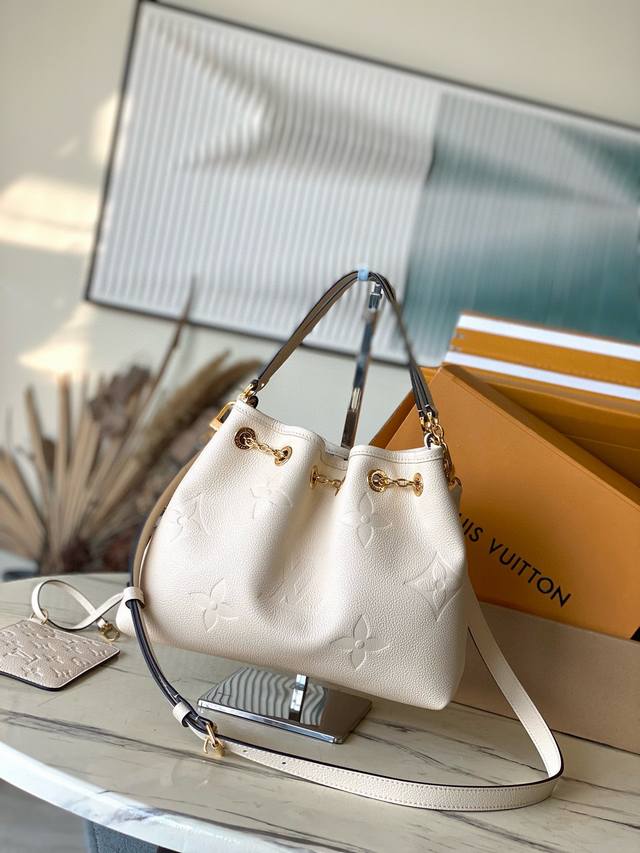 M25452 米白 本款 Lv Bundle 手袋为 Monogram Empreinte 皮革搭配莹亮金属件，以抽绳链释放瞩目光采。雅致手柄和可拆卸并调节的肩