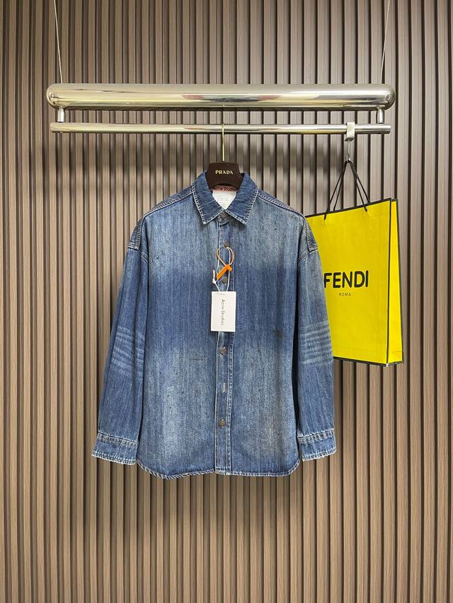 Acne Studios 泼墨做旧牛仔衬衫，定制轻韧竹节棉丹宁料 质感卓越舒适贴肤 以层次渐变的牛仔蓝为底 晕染复古质感 用斑驳漆痕 随性破洞与自然污迹为升华
