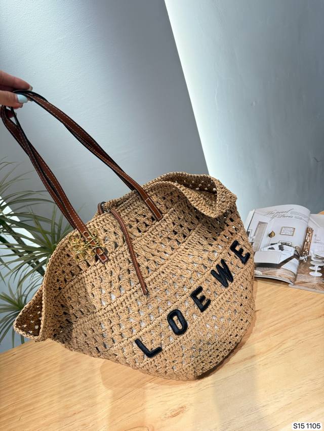 P210 罗意威Loewe 镂空草编托特包 Loewe这款镂空草编托特包，采用天然草编材质，搭配棕色皮革手柄，简约又有度假氛围感。正面品牌字母刺绣，辨识度满分！
