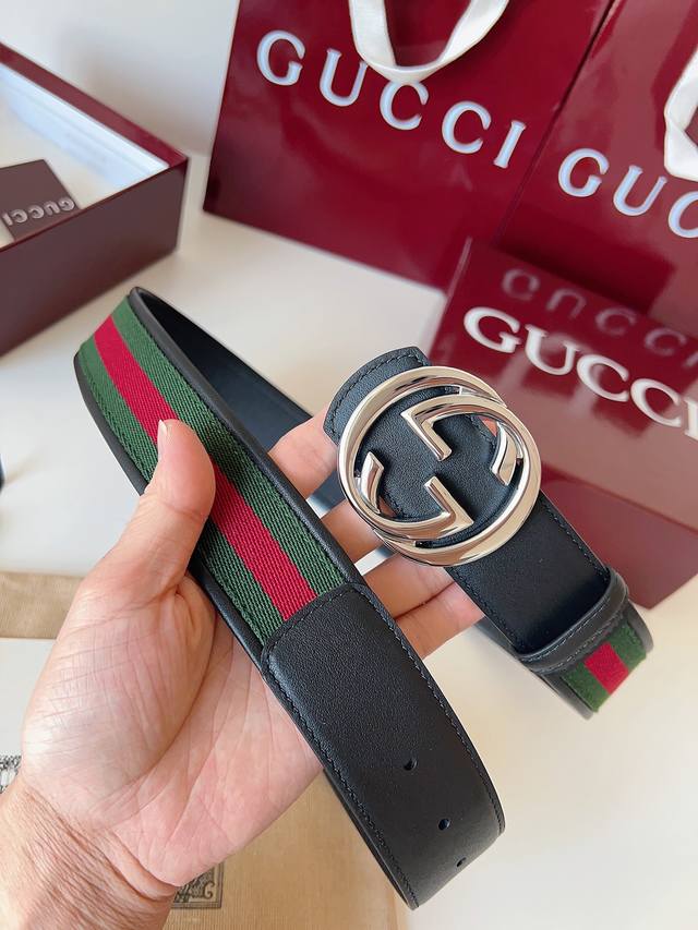 P310 Gucci 这款男士腰带亮眼吸睛，是2026早春系列之一。腰带扣设有一个销钉，可轻松翻转互扣式双G造型配件。一面为红绿织带帆布，另一面为黑色皮革，宽度
