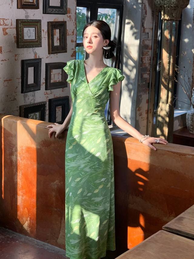 P340 A mint green, bias-cut V-neck dress with ruffled sleeves, exuding a fresh s