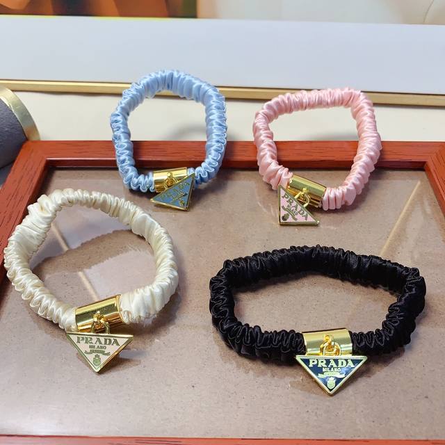 Prada hair tie with logo triangle tag. A versatile and stylish everyday item, a