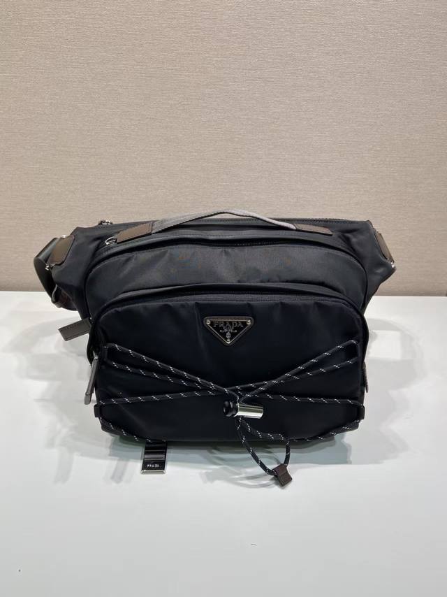 p560 新品邮差包2Vh201 这款多功能动感单肩包将都市风格与户外元素相结合。这款Re-Nylon包设计轻盈、宽敞，外部有一个大口袋，配有皮革饰边。带可调节