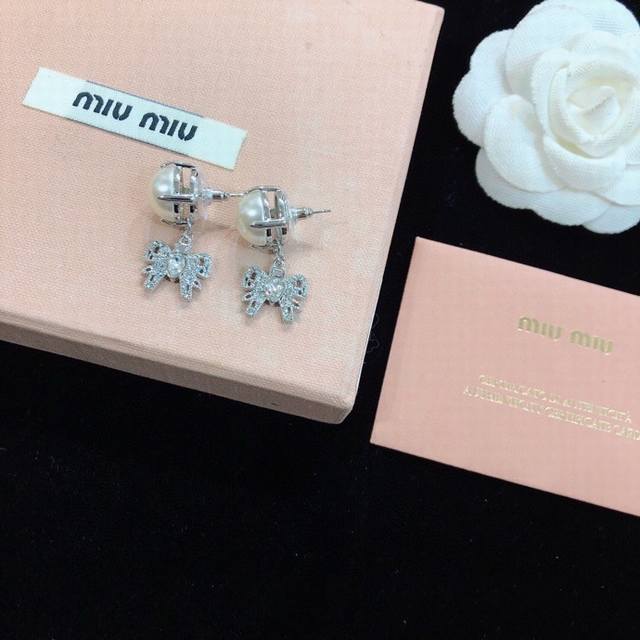 p70 Miumiu Paris Fashion Show's latest bow stud earrings. These earrings were wo