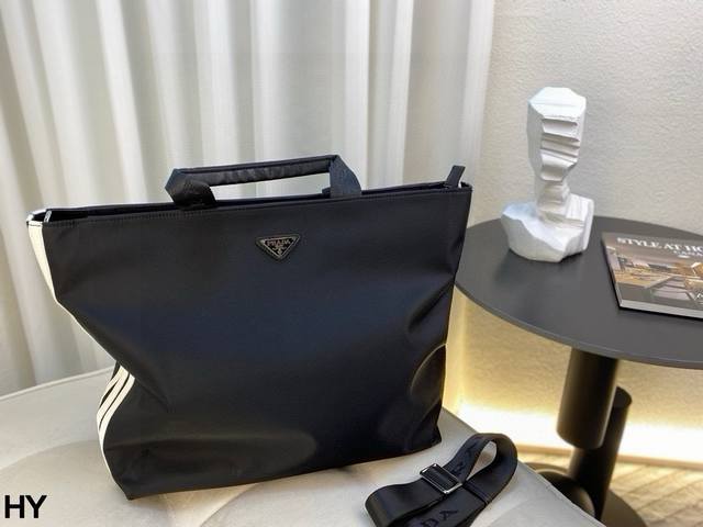 p310 无盒prada X Adidas联名手提包采用尼龙面料，轻便休闲，耐磨抗造，正面饰有金属珐琅三角标，精致十足，侧面拼接Adidas经典三道杠，休闲时尚