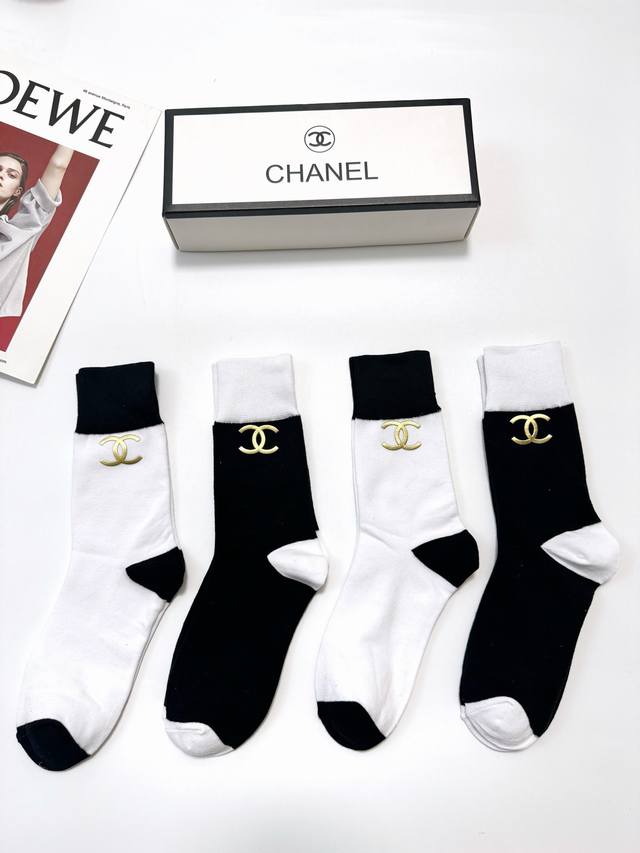 70 A box of 4 pairs of Chanel mid-calf socks with the classic Chanel logo, a top