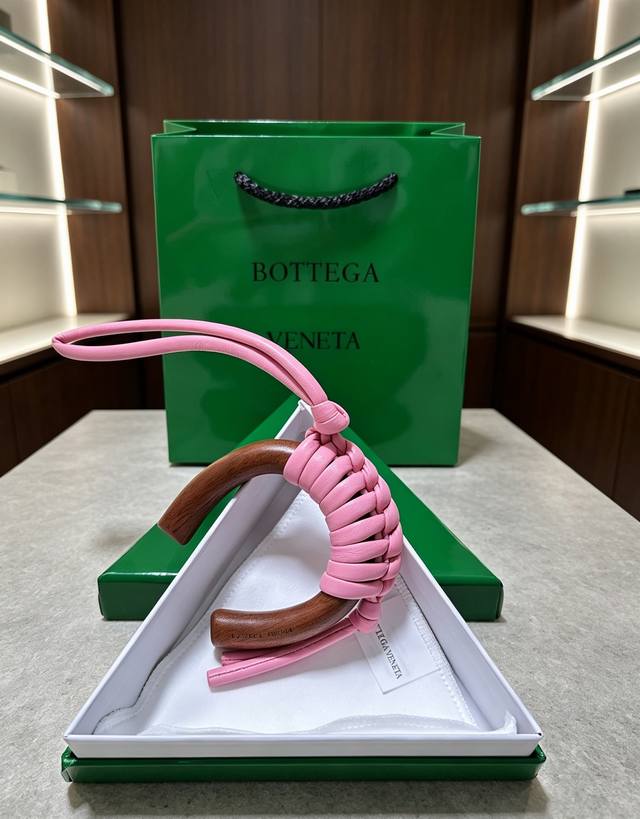 p90-Bottega Veneta 木编挂饰｜把意式极简揣进包里 温润胡桃木弧形轮廓，手工编织小羊皮肌理 柔和粉色自带松弛氛围感 没有繁杂标识，低调的质