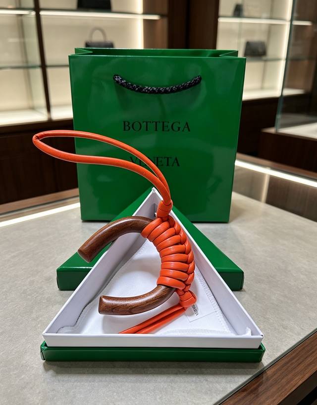 p90-Bottega Veneta 木编挂饰｜把意式极简揣进包里 温润胡桃木弧形轮廓，手工编织小羊皮肌理 柔和活力橙自带松弛氛围感 没有繁杂标识，低调的
