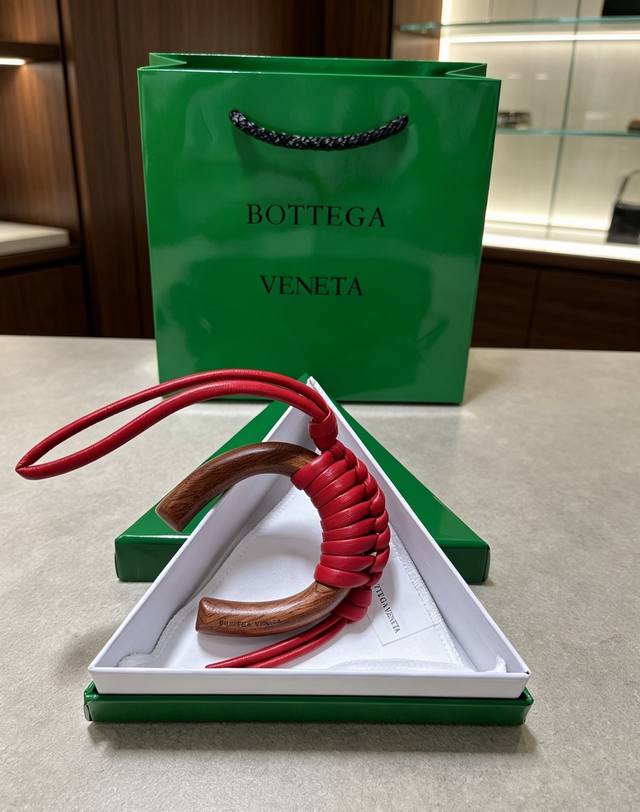 p90-Bottega Veneta 木编挂饰｜把意式极简揣进包里 温润胡桃木弧形轮廓，手工编织小羊皮肌理 柔和大红自带松弛氛围感 没有繁杂标识，低调的质